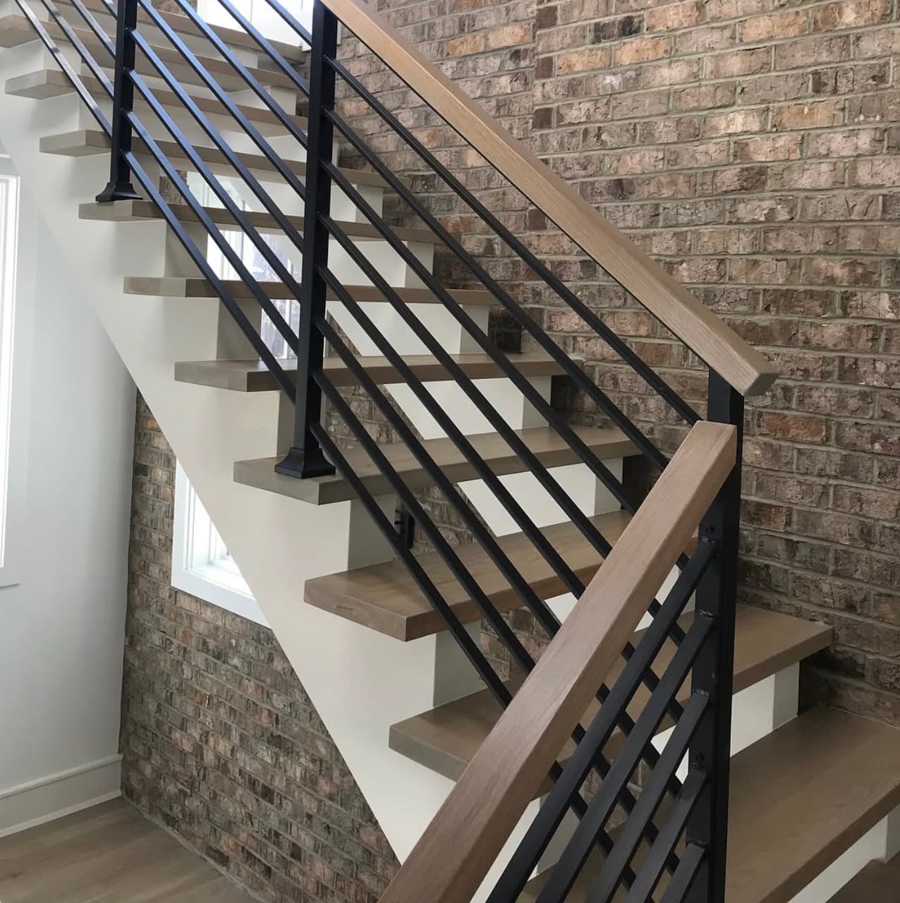 Staircase remodel white oak treads white risers black iron balusters Clayton NC